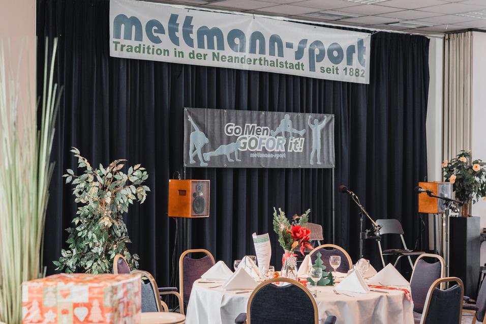 Festlich dekorierter Tisch mit Blumenschmuck und vielschichtigen Menükarten, Hintergrundbanner für Mettmann-Sport.