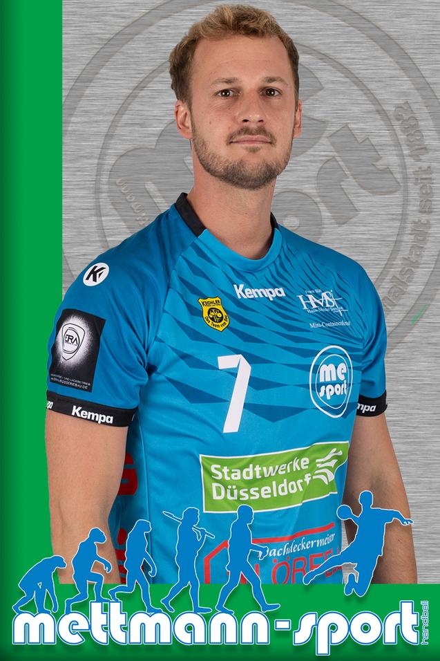 Porträt eines Handballspielers in einem blauen Trikot mit der Nummer 7, lächelnd vor grauem Hintergrund.