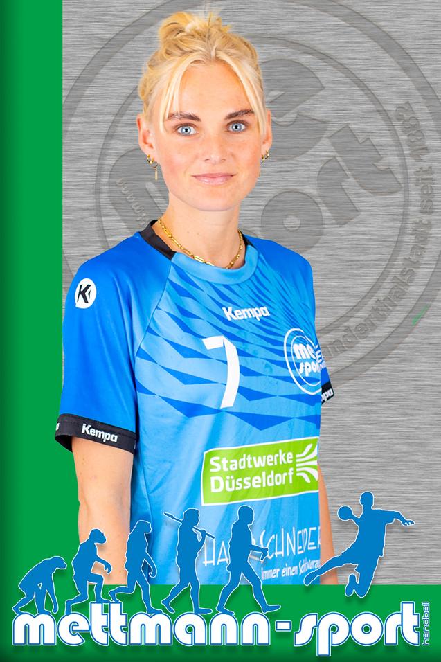 Porträt einer Frau in einem blauen Handballtrikot mit der Nummer 7, lächelnd vor einem grauen Hintergrund.