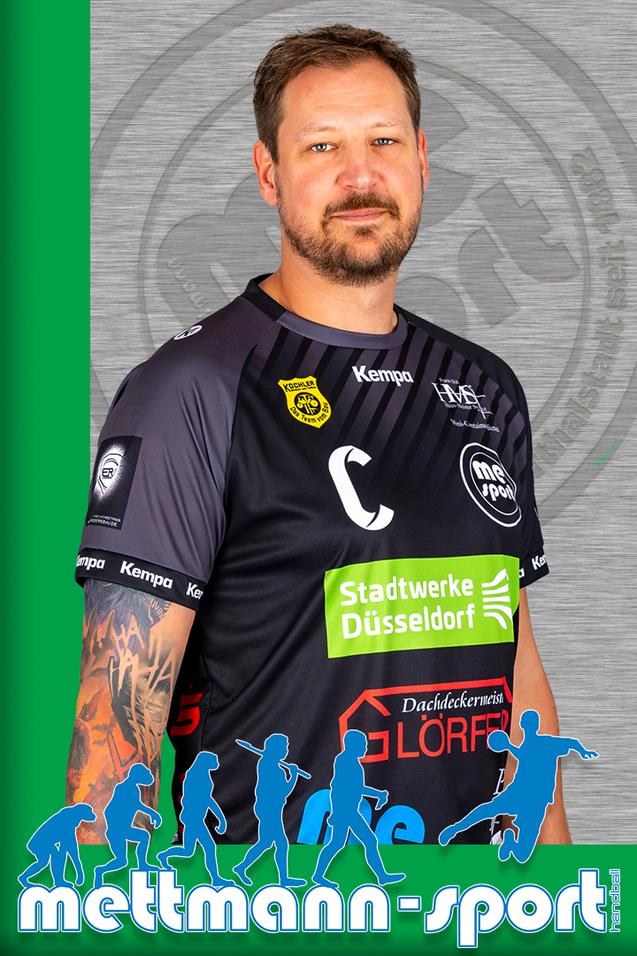 Porträt eines sportlichen Mannes in einem schwarzen Trikot mit Logos, vor einem farbigen Hintergrund.