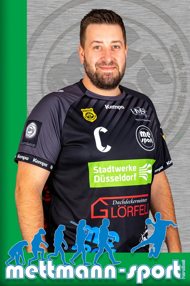 Porträt eines lächelnden Mannes in einem schwarzen Handball-Trikot mit Sponsorenlogo auf grauem Hintergrund.