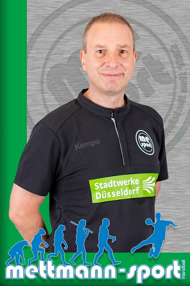 Porträt eines Mannes in schwarzem Sportoberteil mit Logo und Sponsorenschriftzug auf grünem Hintergrund.