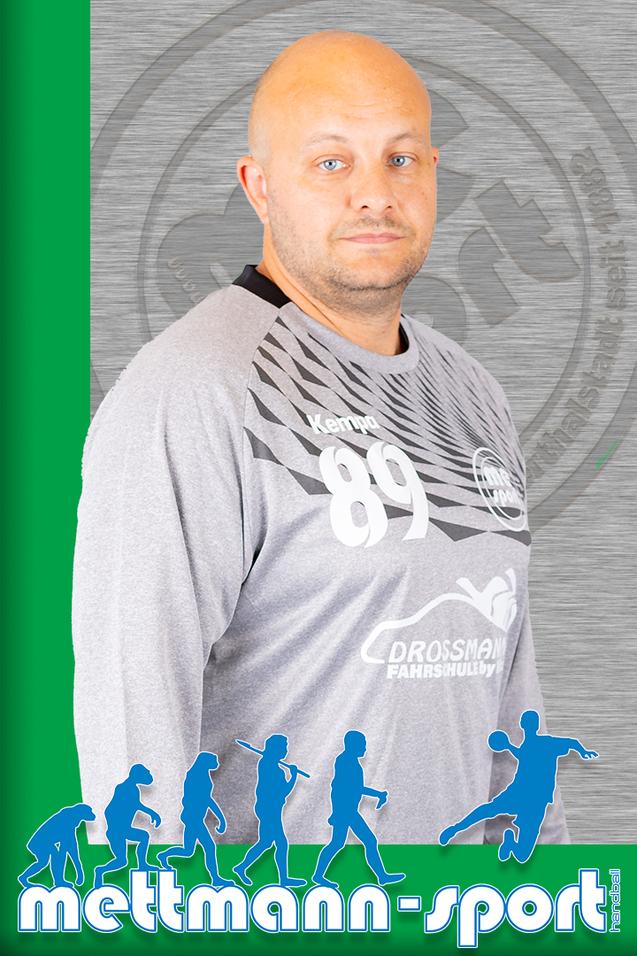 Porträt eines Mannes in einem grauen Sporttrikot mit der Nummer 89, vor einem grünen und metallischen Hintergrund.